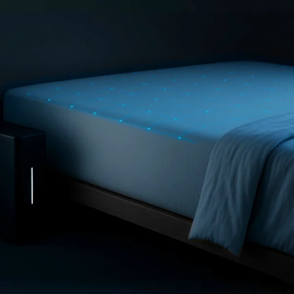 Dark bedroom with glowing blue smart mattress and folded blanket on low platform bed.