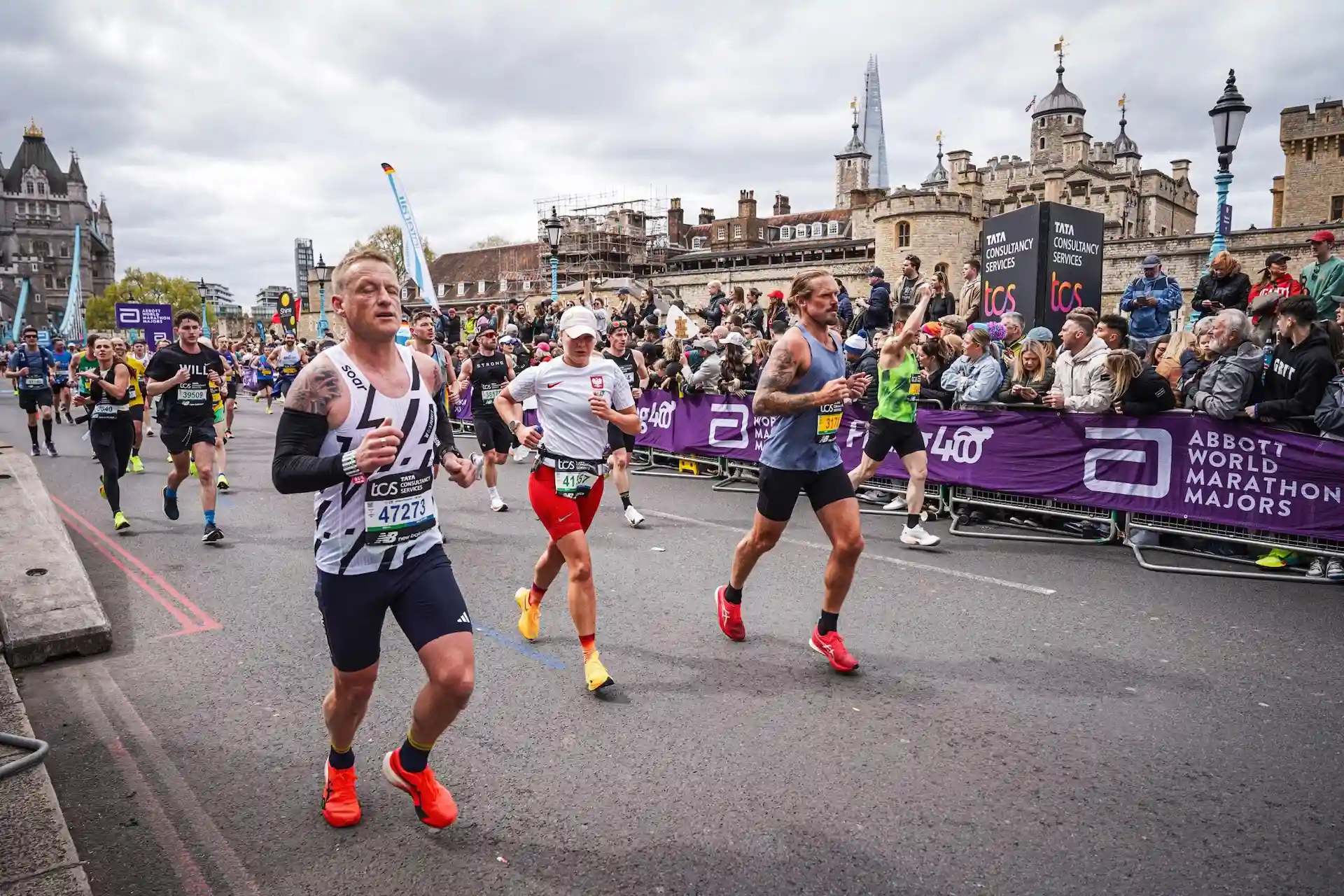 Marathon runners racing through central London with Tower of London and Shard in background