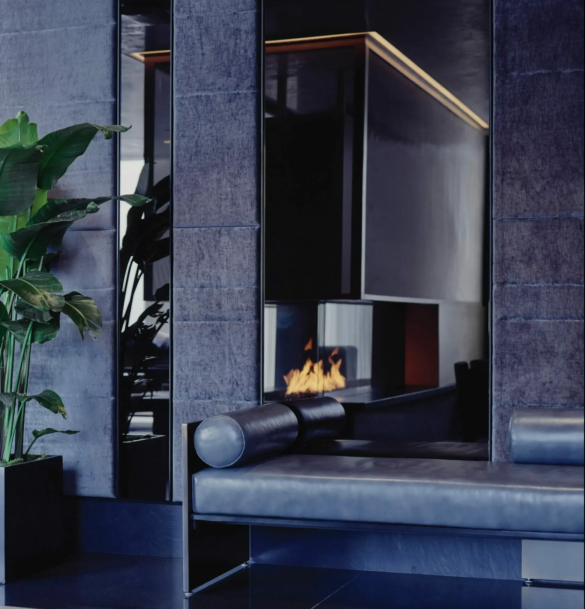Modern interior with glass-enclosed fireplace, dark bench, potted plant, and warm ambient lighting