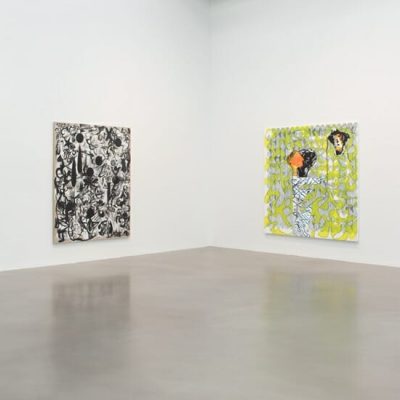 Minimalist gallery interior with white walls, concrete floor, and two abstract paintings; one monochrome, one colorful