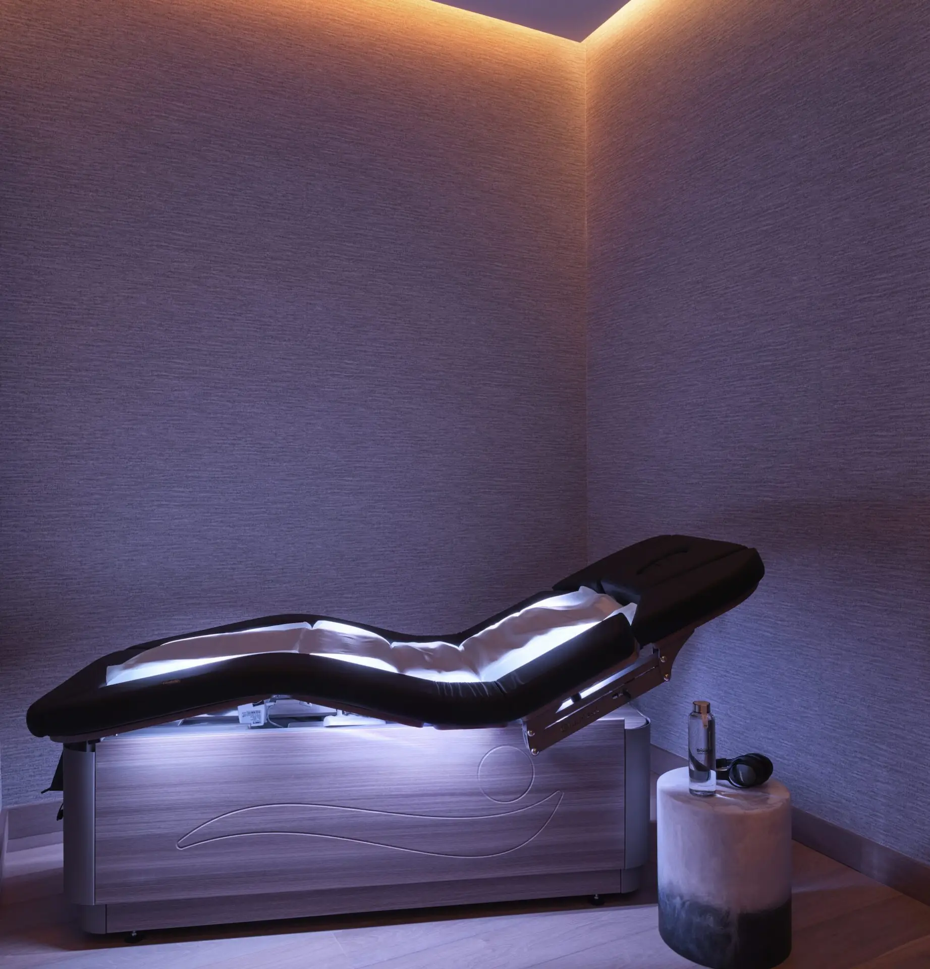 Modern wellness room at Equinox Hotels with illuminated therapy bed, ambient lighting, and calming decor