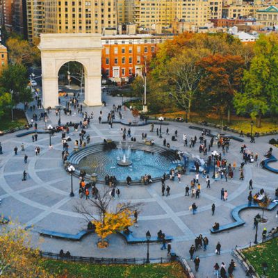 Washington Square Park aerial view with autumn trees, central fountain, and iconic arch in urban setting