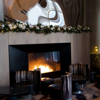 Warm fireplace lounge decorated for the holidays at Equinox Hotel